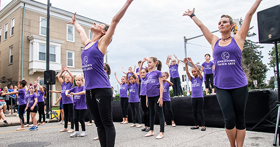 Performers dancing on an outside stage.